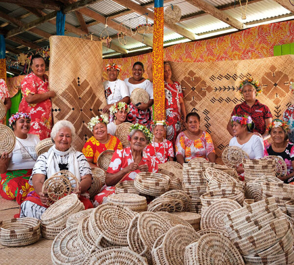 Fijian women artisans of Rise Beyond the Reef seated with hand-woven baskets and mats